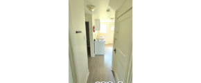a narrow hallway with a white refrigerator next to it