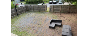 a backyard with a wooden bench and a wooden fence
