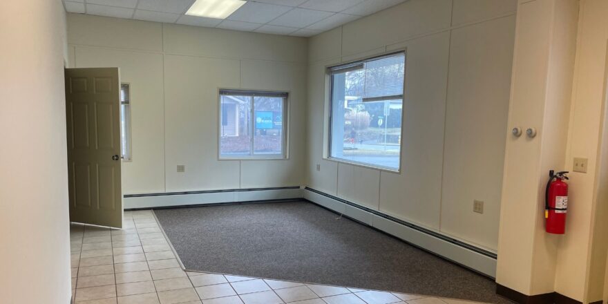 an empty room with a tile floor and two windows