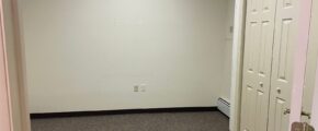 an empty room with two white doors and a pink wall