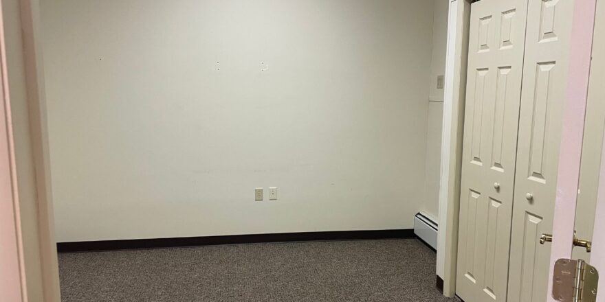 an empty room with two white doors and a pink wall