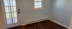 an empty room with a ceiling fan and wooden floors
