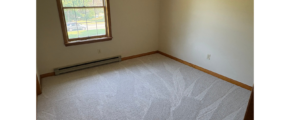 an empty room with a window and a radiator