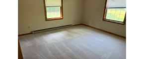 an empty room with two windows in it