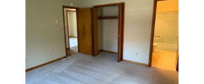 an empty room with a door and a closet