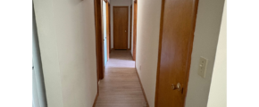 a long hallway with a door and a light on