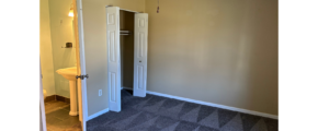 an empty room with a ceiling fan and a door