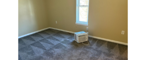 an empty room with a ceiling fan and a window