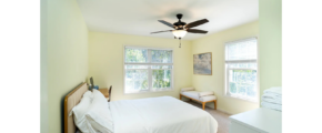 a bedroom with a bed and a ceiling fan