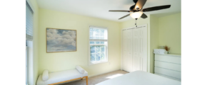 a bedroom with a ceiling fan and a bed