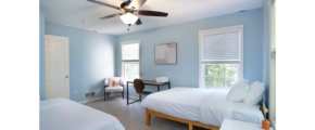 a bedroom with two beds and a ceiling fan