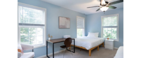 a bedroom with two beds and a desk
