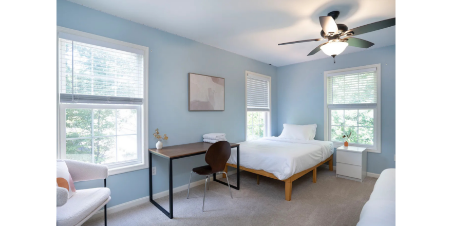 a bedroom with two beds and a desk
