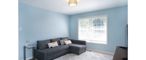 a room with blue walls and a gray couch