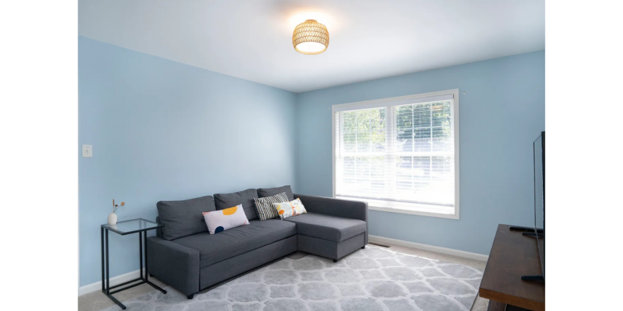 a room with blue walls and a gray couch