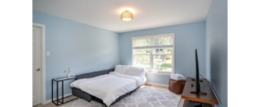 a bedroom with blue walls and a white bed