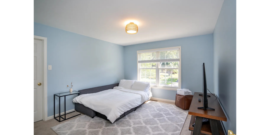 a bedroom with blue walls and a white bed
