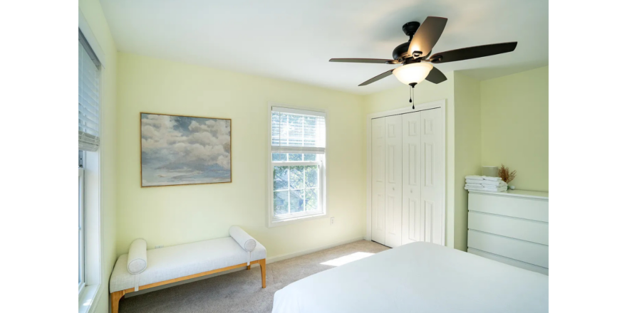 a bedroom with a ceiling fan and a bed