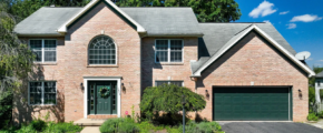 a brick house with a green garage door