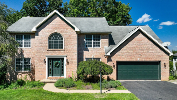 a brick house with a green garage door