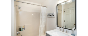 a bathroom with a sink, mirror, and bathtub