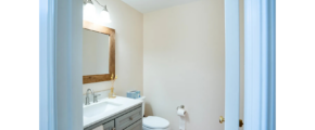 a bathroom with a toilet, sink and mirror