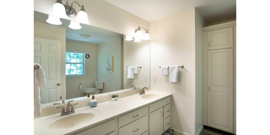 a bathroom with two sinks and a large mirror