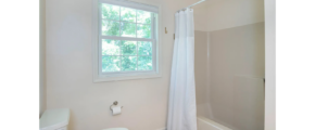 a bathroom with a toilet, shower, and sink