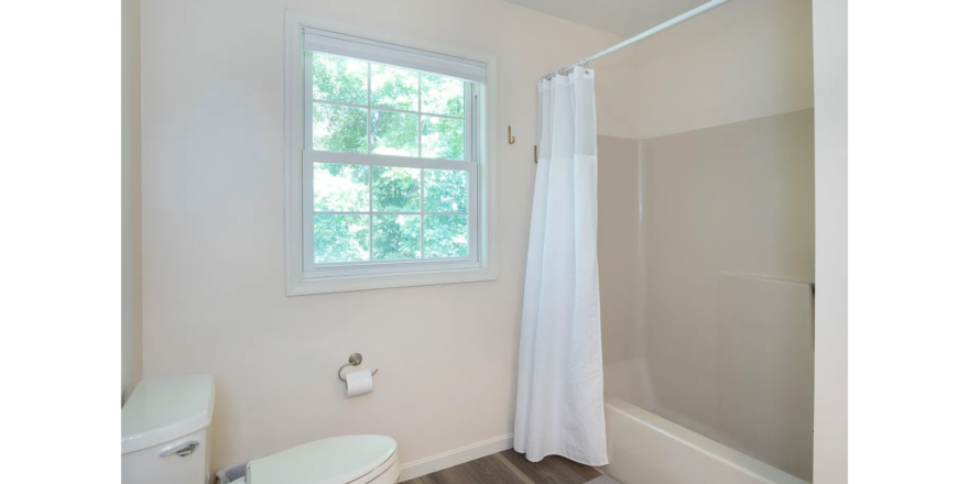 a bathroom with a toilet, shower, and sink