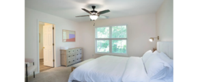 a room with a bed and a ceiling fan