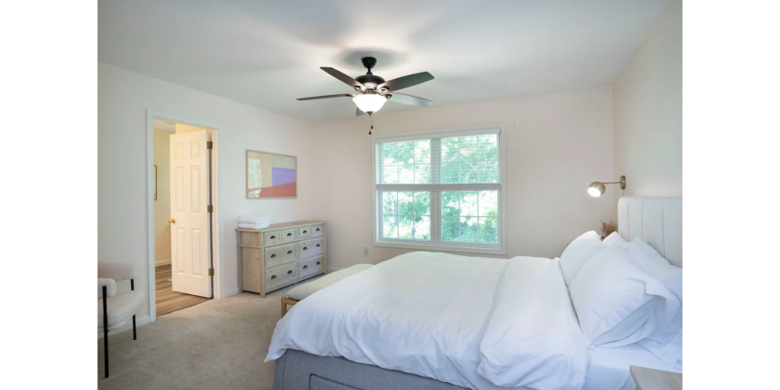 a room with a bed and a ceiling fan