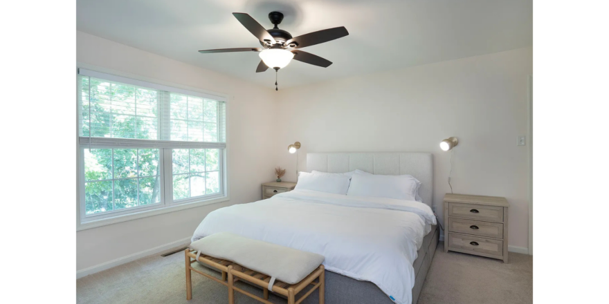 a bedroom with a bed and a ceiling fan