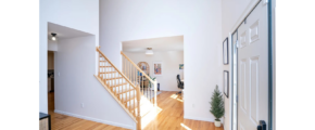 a white house with a wooden floor and stairs