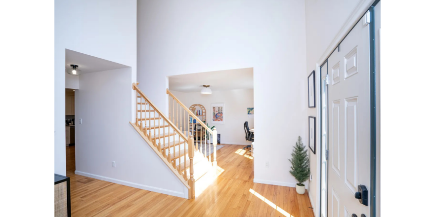 a white house with a wooden floor and stairs