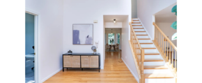 a white room with a wooden floor and stairs