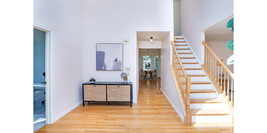 a white room with a wooden floor and stairs