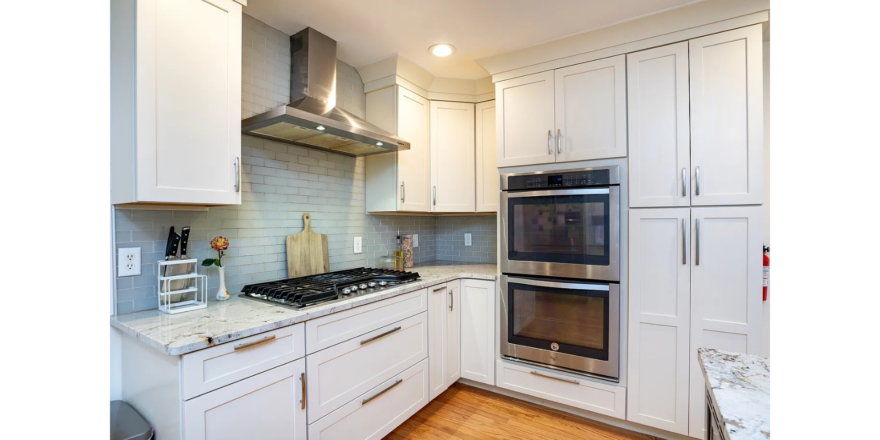 a kitchen with white cabinets and stainless steel appliances