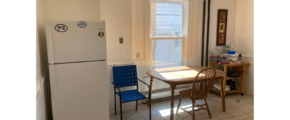 a kitchen with a refrigerator, table and chairs