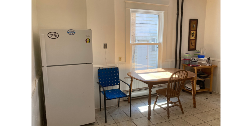 a kitchen with a refrigerator, table and chairs