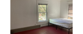 an empty room with a bed and a window