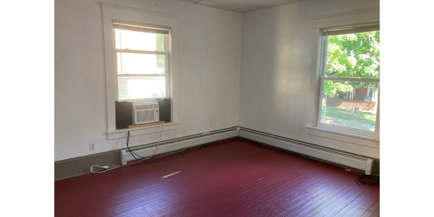an empty room with a red floor and a window