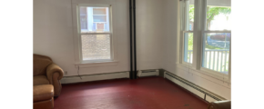 an empty room with a chair and a window