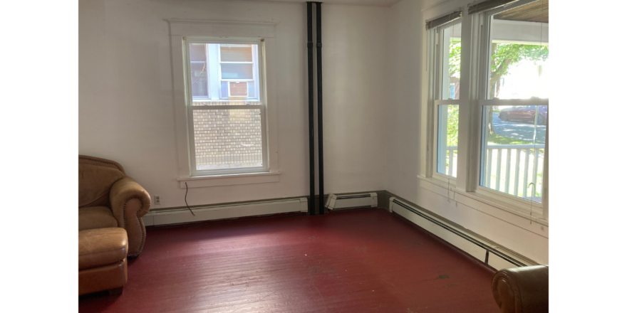 an empty room with a chair and a window
