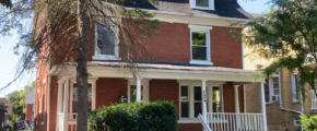 a red brick house with a white porch