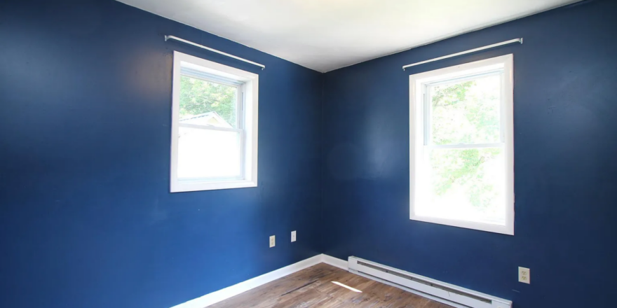 a empty room with blue walls and wood floors