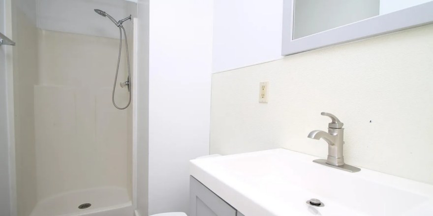 a bathroom with a toilet, sink, and shower