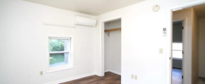 an empty room with hard wood floors and white walls