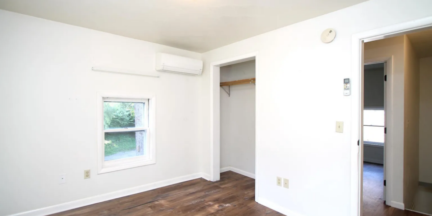 an empty room with hard wood floors and white walls