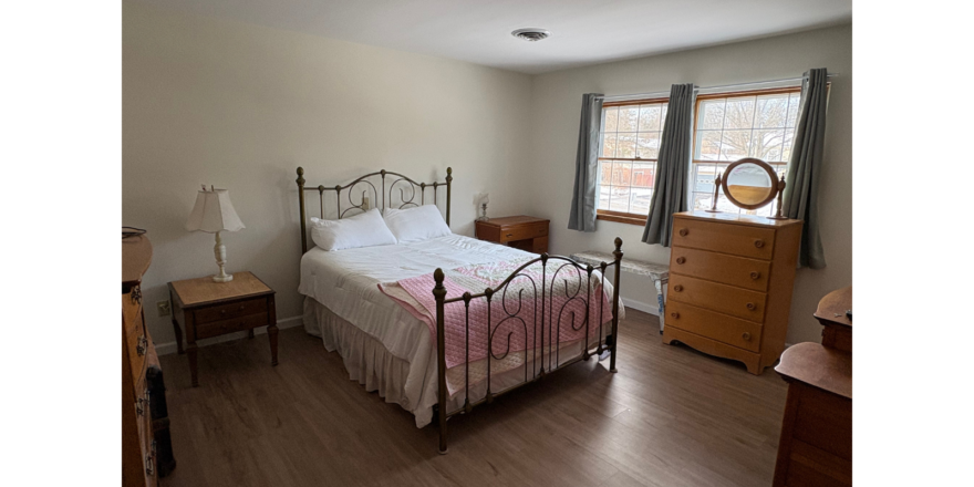 a bed room with a neatly made bed and a dresser