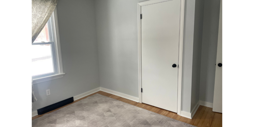 an empty room with a door and a window